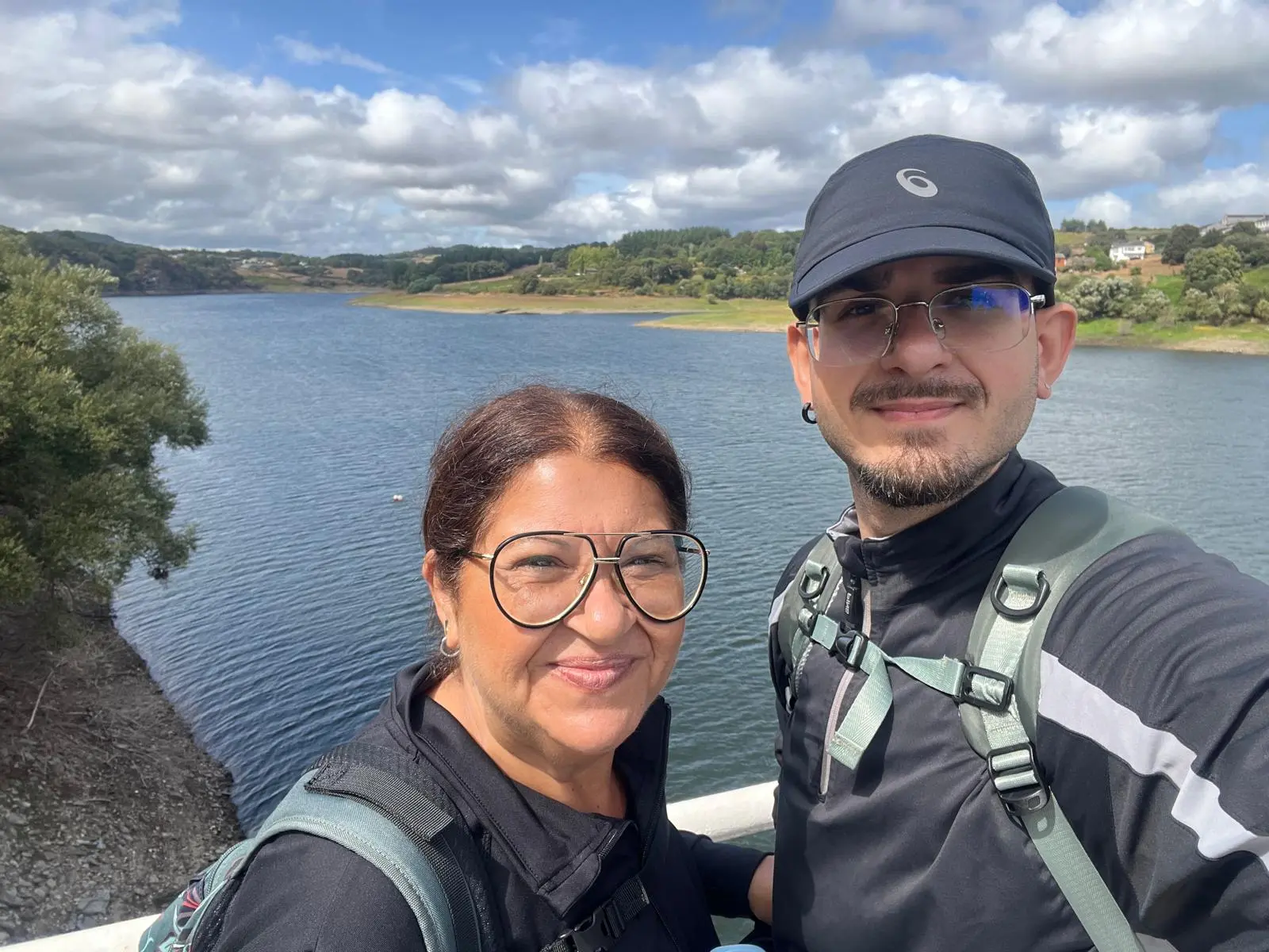Selfie of Matías and his mother with backpacks, in front of a reservoir on the Camino de Santiago
