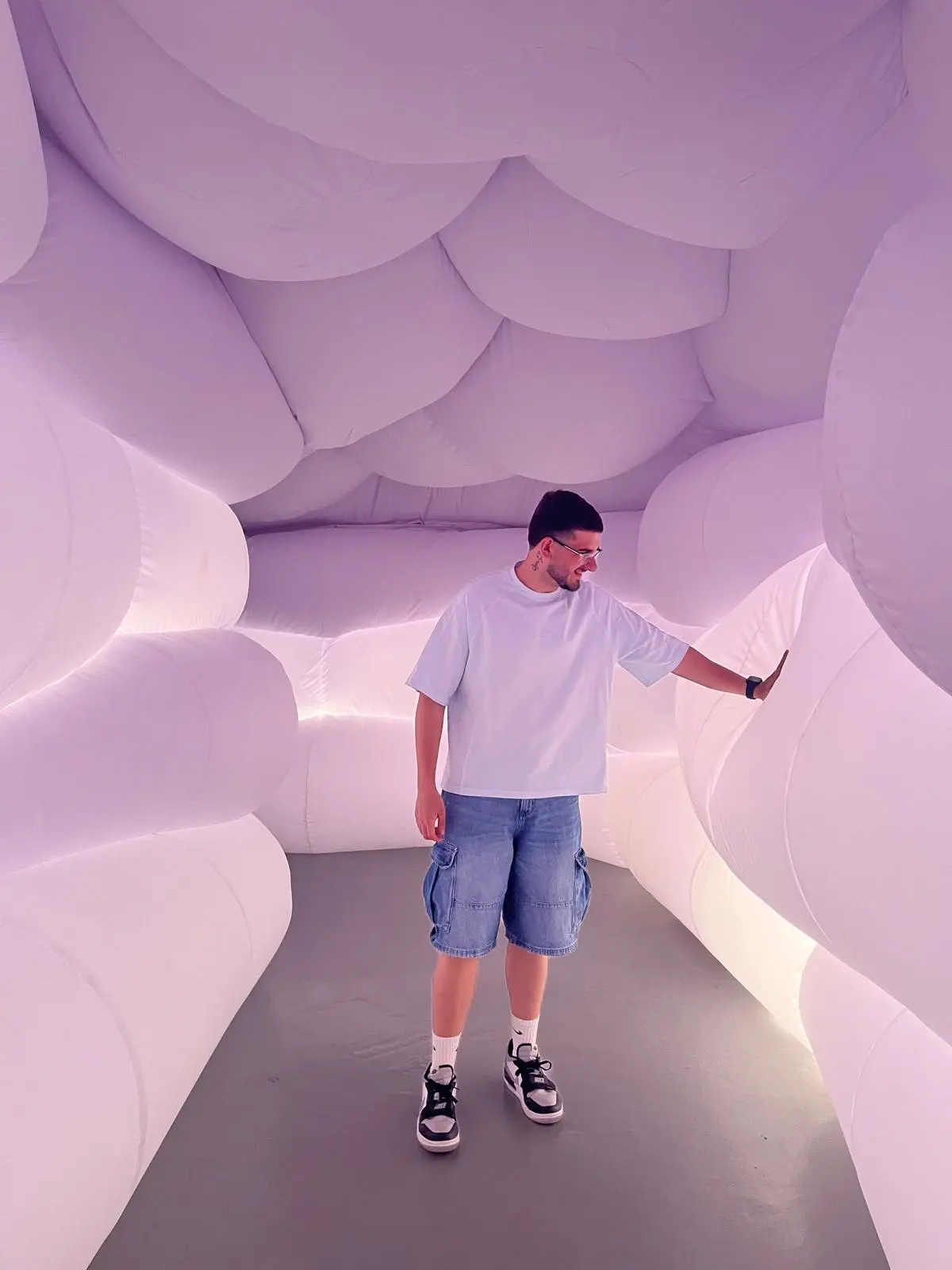 Matías standing in a lilac inflatable art installation